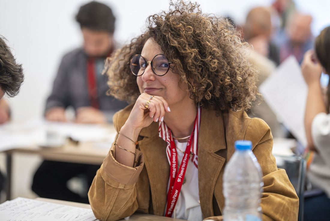 A participant listening, chin in hand, smiling